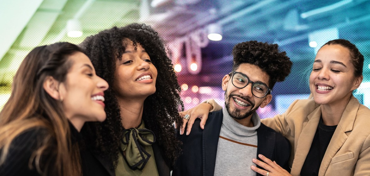 This is an image of 4 colleagues gathered together laughing and smiling.