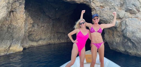 Liz Hilliard (R) pictured with her partner Lee (L). The couple are pictured here wearing pink swimming costumes on a boat beside caves in the sea.