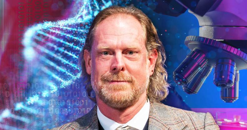 This is an image of University of Cambridge professor Giles Oldroyd. He is smiling and wearing a tweed suit. He is in front of a backgroud consisting of science related materials like DNA and a microscope