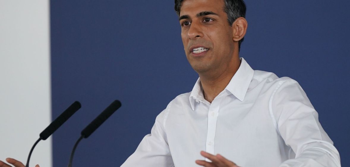 Rishi Sunak at a press conference in a white shirt.