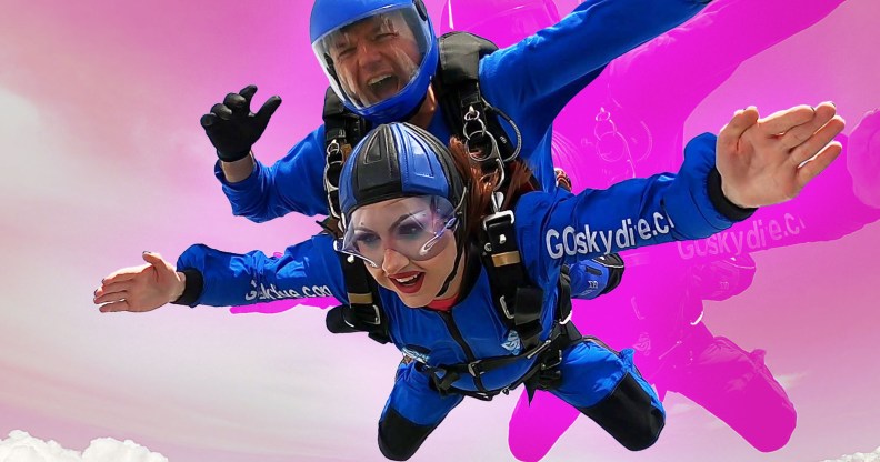 The image shows Rosie Zinfandel, a drag queen, skydiving. She is falling through the air and can be seen wearing full make-up and fake eyelashes.