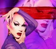Sasha Velour in a sheer purple top holding her face with her hands.