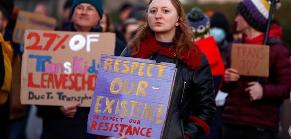 A group of trans activists hold signs of solidarity.