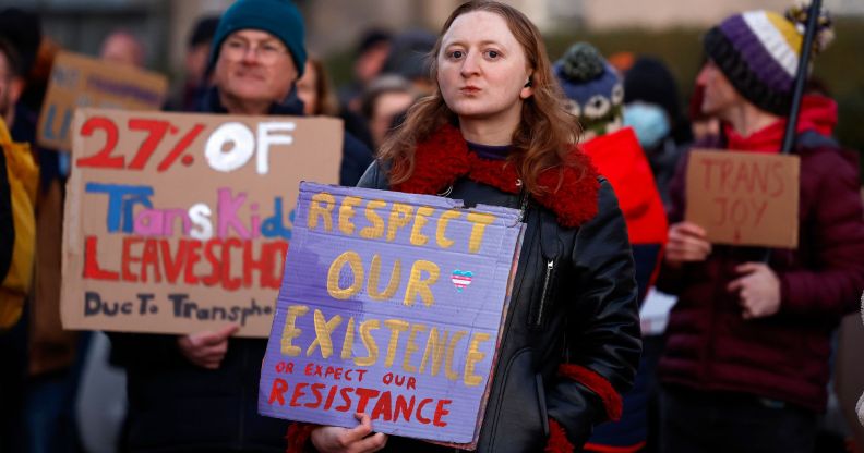 A group of trans activists hold signs of solidarity.