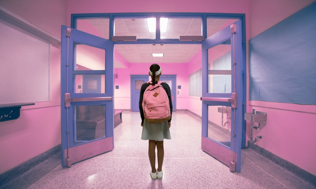 A young person walking down a school hallway
