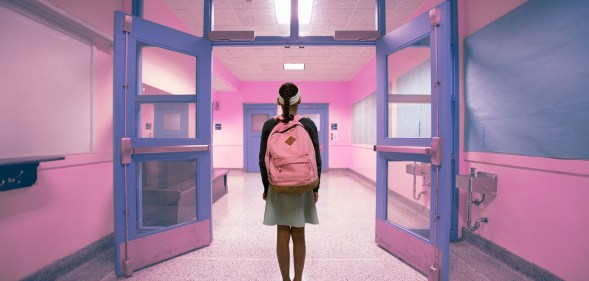 A young person walking down a school hallway