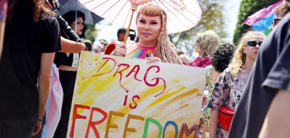 A person holds up a sign reading 'drag is freedom' amid a protest against surging anti-LGBTQ+ bills in the US like Tennessee's drag ban