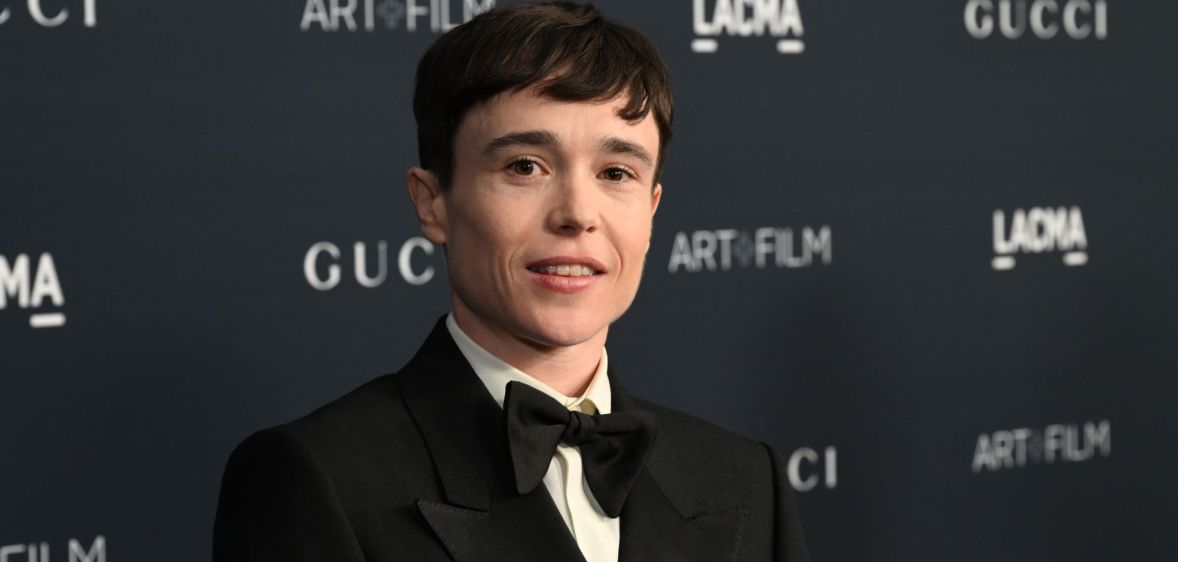 Elliot Page looks at the camera while wearing a white shirt, black bow tie and black suit jacket