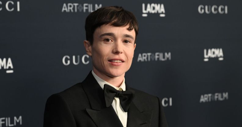 Elliot Page looks at the camera while wearing a white shirt, black bow tie and black suit jacket