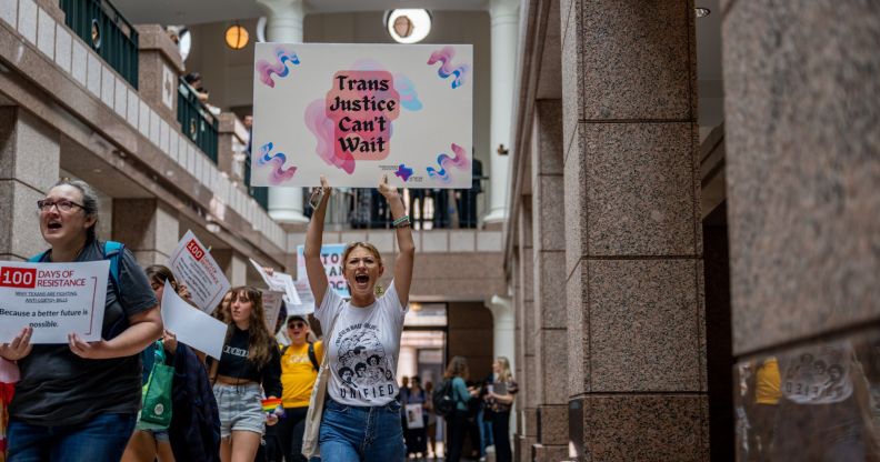 A person holds up a sign reading 'trans justice can't wait' as LGBTQ+ and trans rights advocates protest in the Texas Capitol Building against the wave of anti-LGBTQ+ bills in the state including a gender-affirming healthcare ban for trans youth