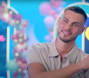 Love Island 2023 contestant George Fensom wears a grey shirt as he sits down for an interview