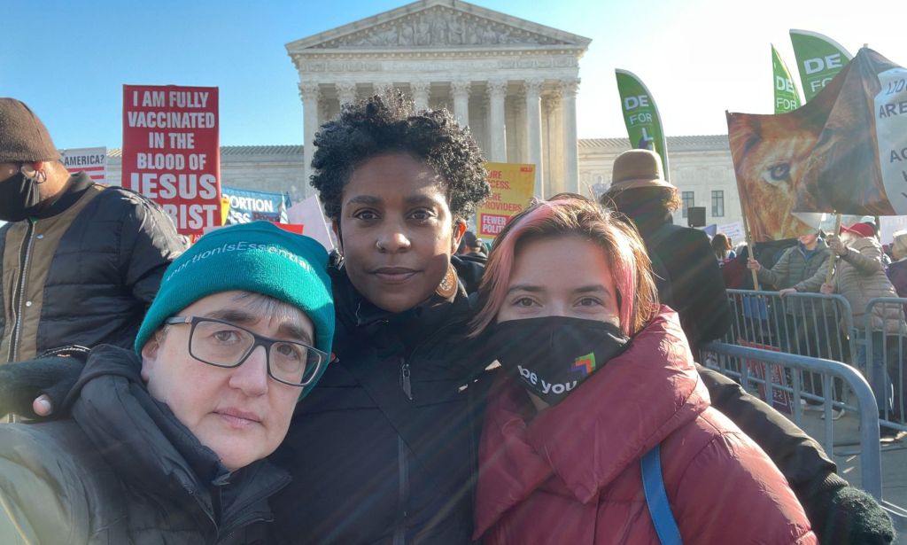 National LGBTQ Task Force's Cathy Renna, Kierra Johnson and Mayra Hidalgo Salazar stand amid protests outside the Supreme Court as the court heard a case that would overturn Roe v Wade
