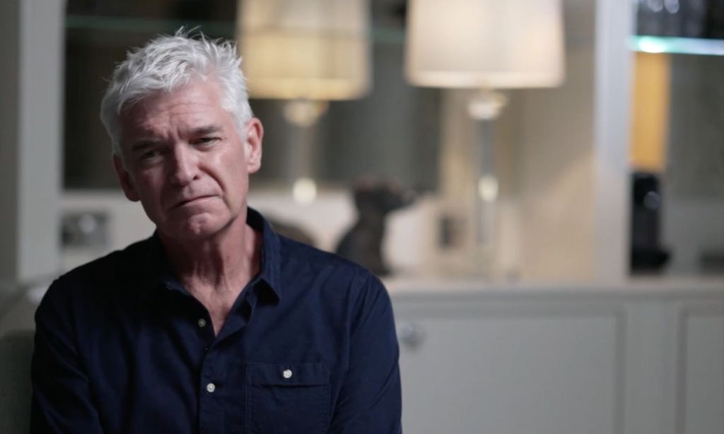 Phillip Schofield looks sadly into the corner while wearing a dark shirt during a BBC interview