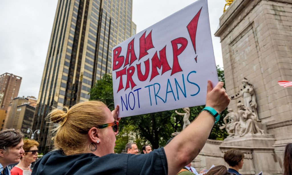 A person holds up a sign reading 'ban Trump not trans' in protest against the Republican's continued attacks against the trans community