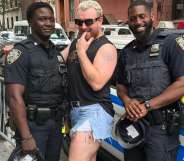 Sam Smith, a white non-binary person with blonde hair, posing in between two Black, male NYPD officers