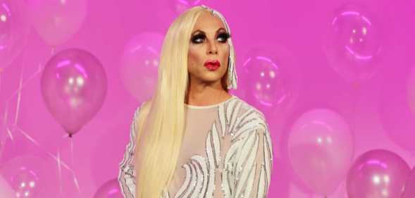The Sherry Vine Variety Show star Sherry Vine with blonde hair and a silver dress in front of a pink background