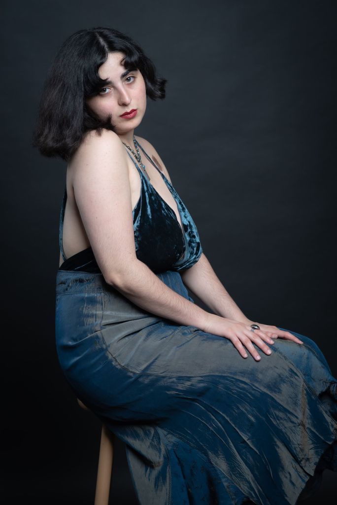 Skaly, a singer, songwriter and composer. Here they are pictured wearing a dress in a posed photograph.