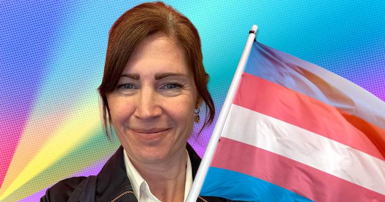 Aby Hawker, CEO and founder of TransMission PR, a communications consultancy which specialises in trans and non-binary inclusion and awareness, next to a trans Pride flag