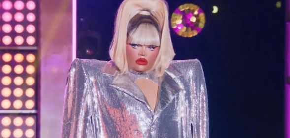 Kandy Muse in a silver coat and high blonde ponytail ready to perform the final lip sync for the crown against Jimbo.