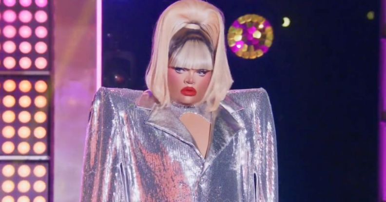 Kandy Muse in a silver coat and high blonde ponytail ready to perform the final lip sync for the crown against Jimbo.