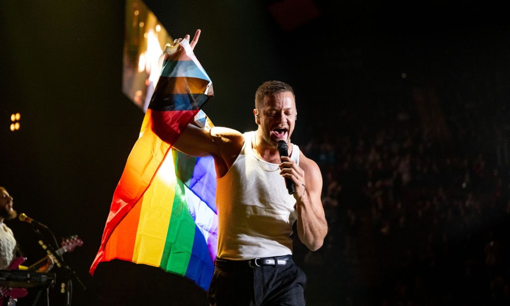 Dan Reynolds holds LGBTQ+ pride flag.