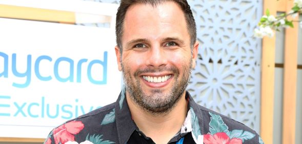 Dan Wootton, in a Hawaiian shirt, smiles towards a camera.