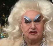 Drag performer Darcelle XV wears blue eye makeup and a light blond wig as she stands outside her space in Portland, Oregon