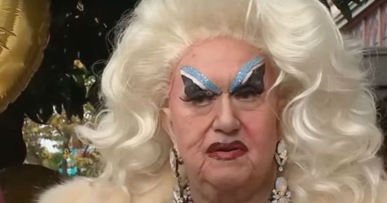 Drag performer Darcelle XV wears blue eye makeup and a light blond wig as she stands outside her space in Portland, Oregon