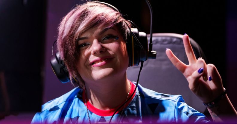 Emma 'Emzii' Rose sat in a gaming chair, making a peace simple during an esports event.