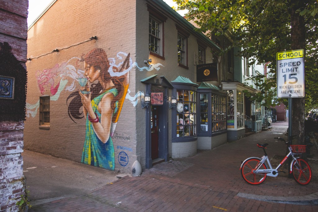 A street mural of a woman sipping coffee