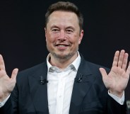 Owner of Twitter Elon Musk sits with his hands up
