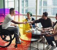 This is an image of a man in a wheelchair shaking another mans hand. There are two women smiling. They are in a bright and airy office.