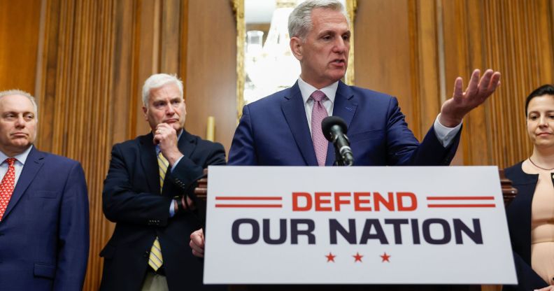 (L-R) Steve Scalise, Tom Emmer, Kevin McCarthy and Elise Stefanik stand around a press room discussing the recently passed National Defense bill, with McCarthy at a podium that says "defend our nation."