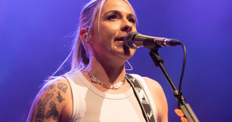 Lucy Spraggan sings into a microphone at a gig.