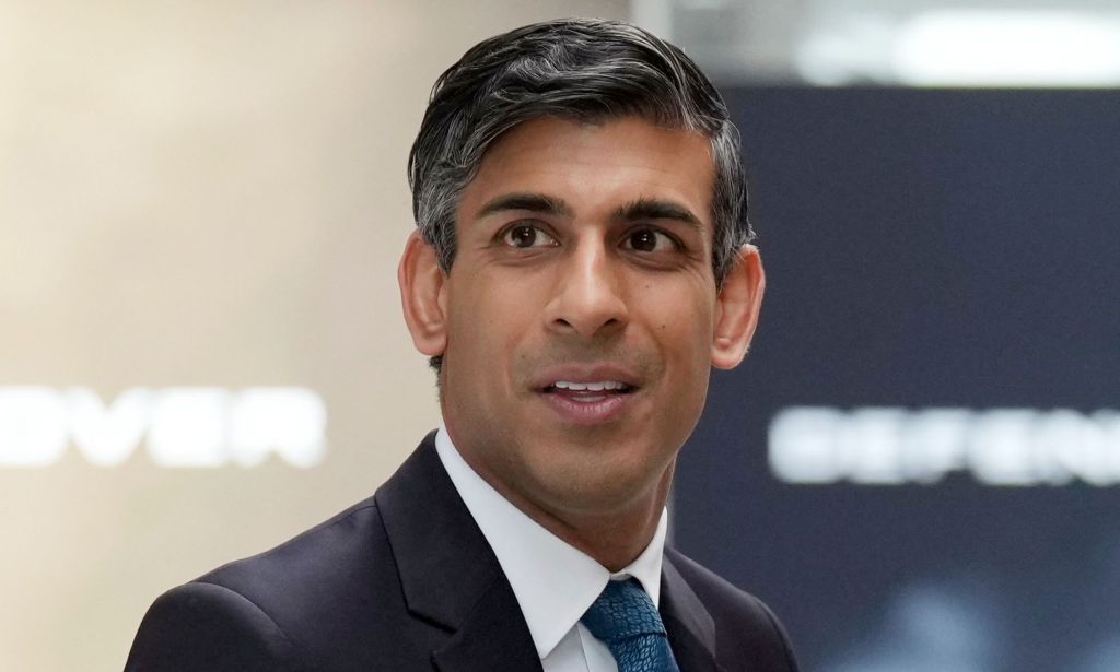 Rishi Sunak looking off into the distance, while wearing a suit and blue tie.