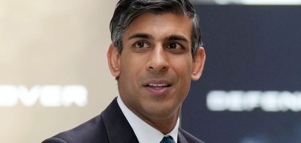 Rishi Sunak looking off into the distance, while wearing a suit and blue tie.