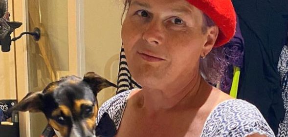 Sarah Jane Baker, in a red cap, holds her dog.