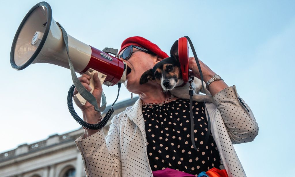 Sarah Jane Baker holds her dog and a megaphone.