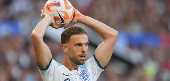 Footballer Jordan Henderson wears an England strip and gets ready to throw a football over his head during a match