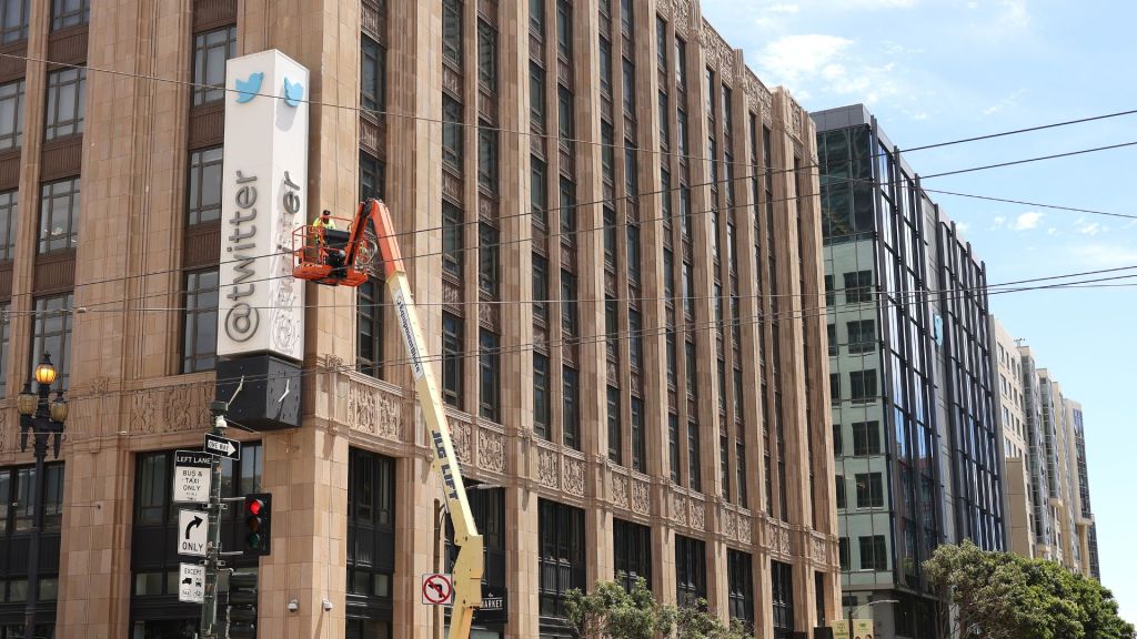 A worker on a crane removes letters from the Twitter sign outside its headquarters in San Francisco, California - police halted the removal of the letters shortly after