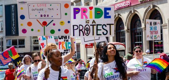Revellers hold signs at Brighton Pride 2022