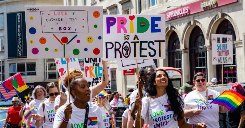 Revellers hold signs at Brighton Pride 2022