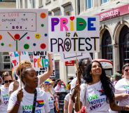 Revellers hold signs at Brighton Pride 2022