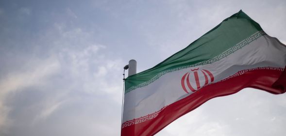 Stock image of red, white and green Iranian flag blowing in the wind