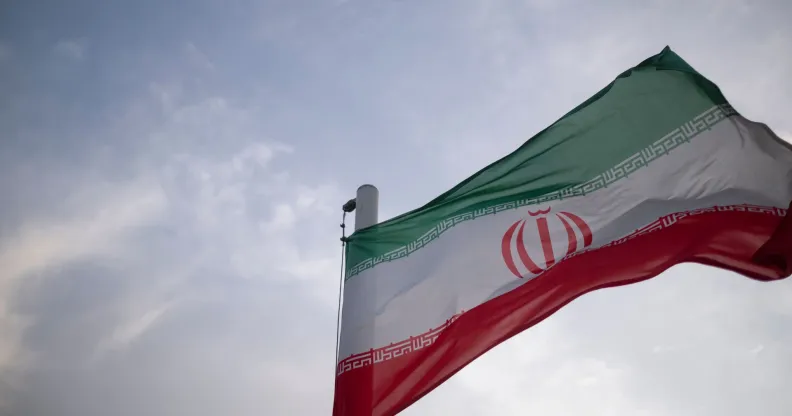 Stock image of red, white and green Iranian flag blowing in the wind
