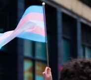 Stock image of a person holding a trans Pride flag