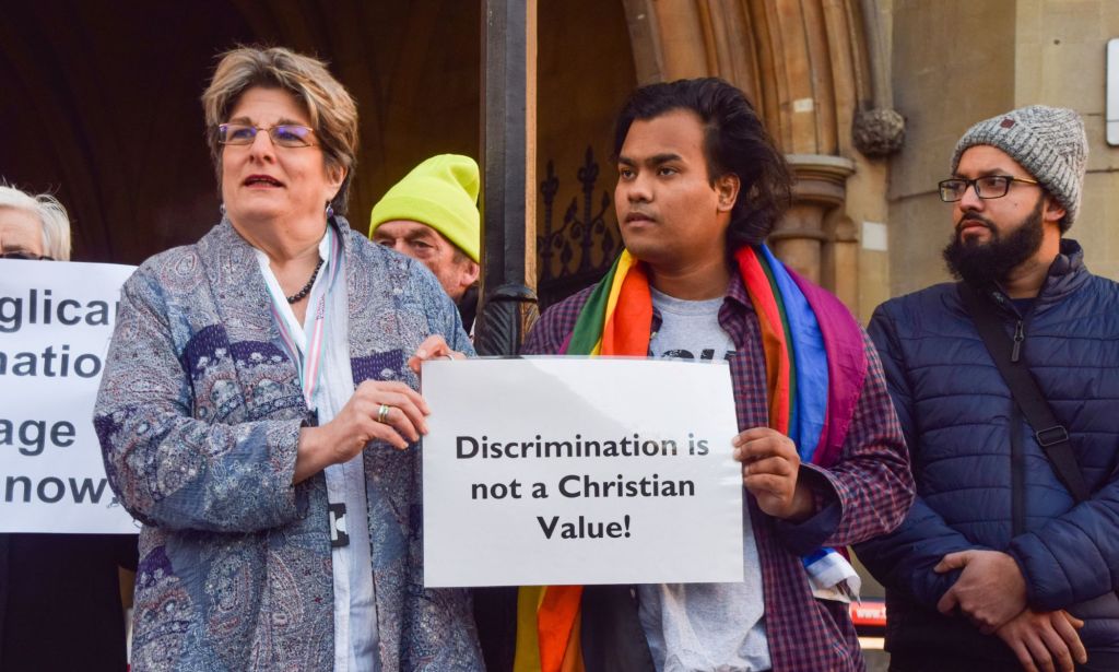 LGBTQ+ Christians hold up a sign reading "discrimination is not a Christian value" as they hold a protest outside a Church of England Synod meeting on blessings for same-sex couples