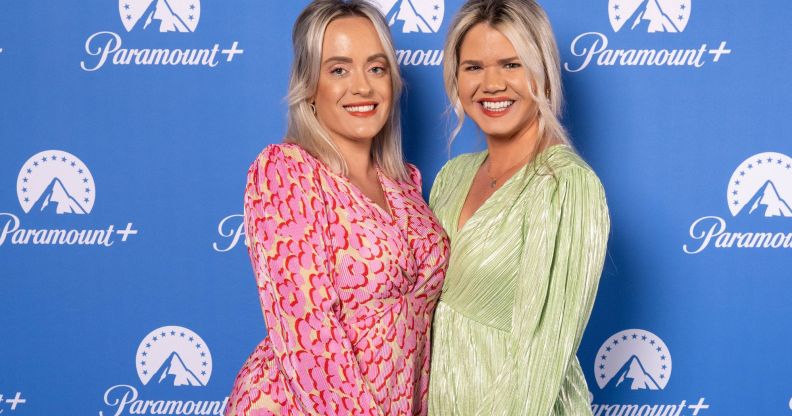Lesbian couple Megan and Whitney Bacon-Evans, who are also campaigners for fertility equality, wear brightly colours dressed as they hold each other close and smile for the camera