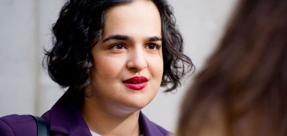 Labour MP Nadia Whittome pictured outdoors doing an interview. She is wearing a purple blazer.