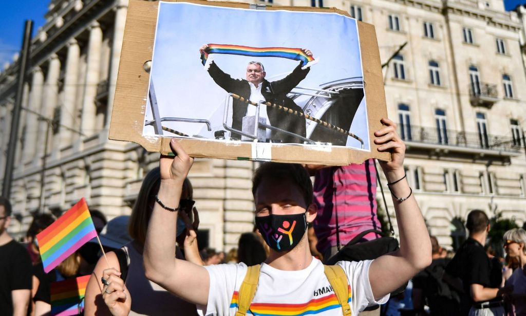 A person holds up a sign of Hungary's leader Viktor Orbán holding a rainbow scarf during an LGBTQ+ protest